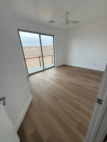 Empty room featuring light wood finished floors and a ceiling fan