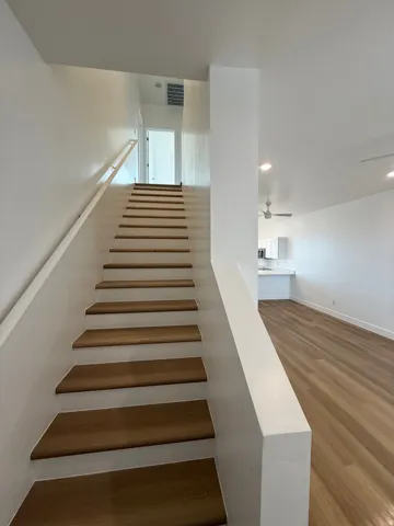 Staircase featuring wood finished floors and recessed lighting