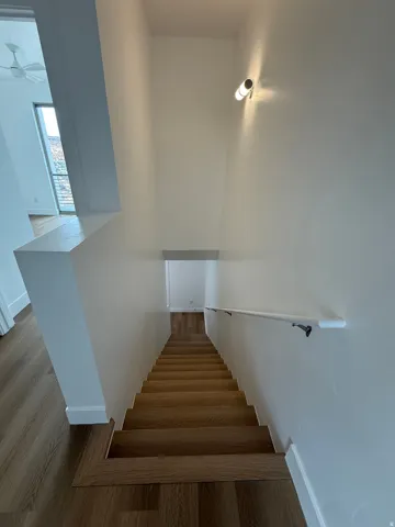 Stairs with wood finished floors and baseboards