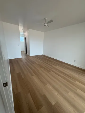 Unfurnished room featuring light wood finished floors and baseboards