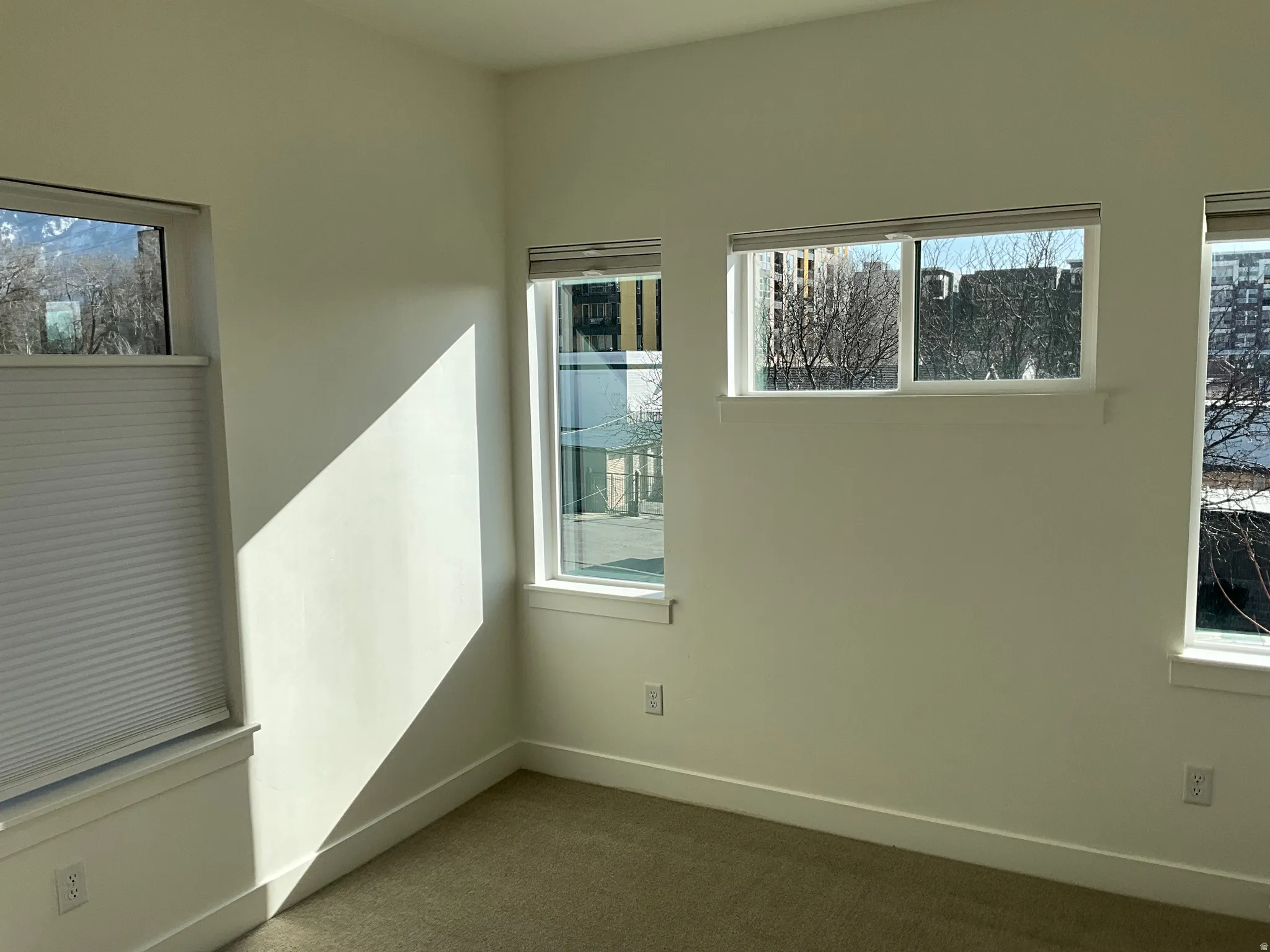 Spare room featuring dark colored carpet and healthy amount of natural light