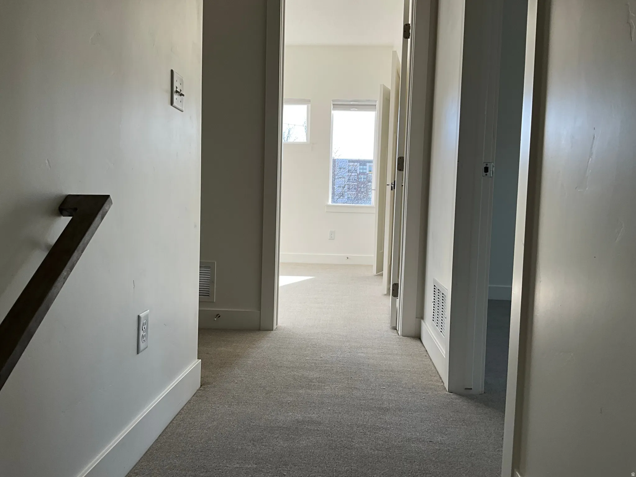 Hall featuring light carpet and baseboards