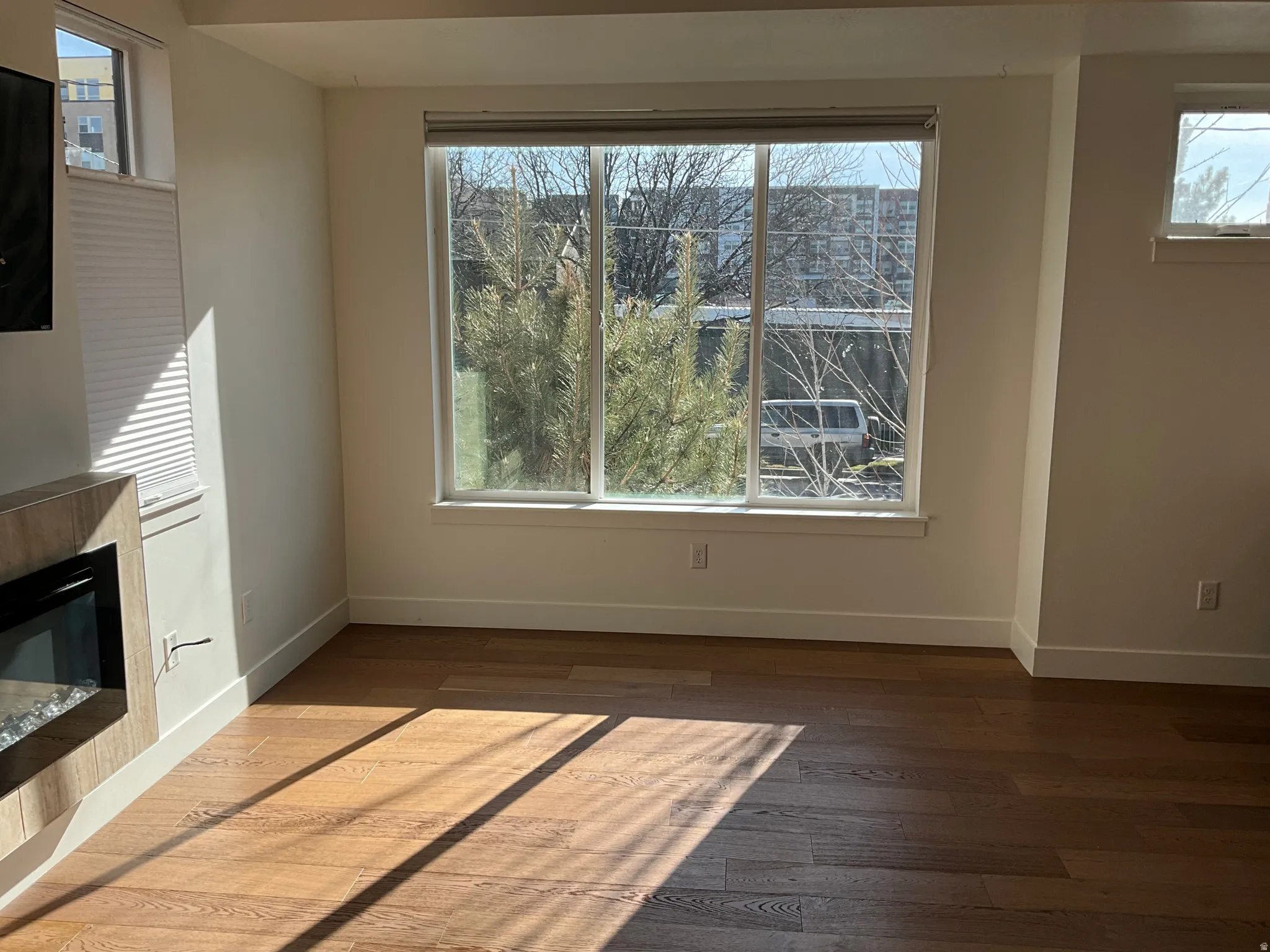 Unfurnished dining area with a glass covered fireplace and dark wood finished floors
