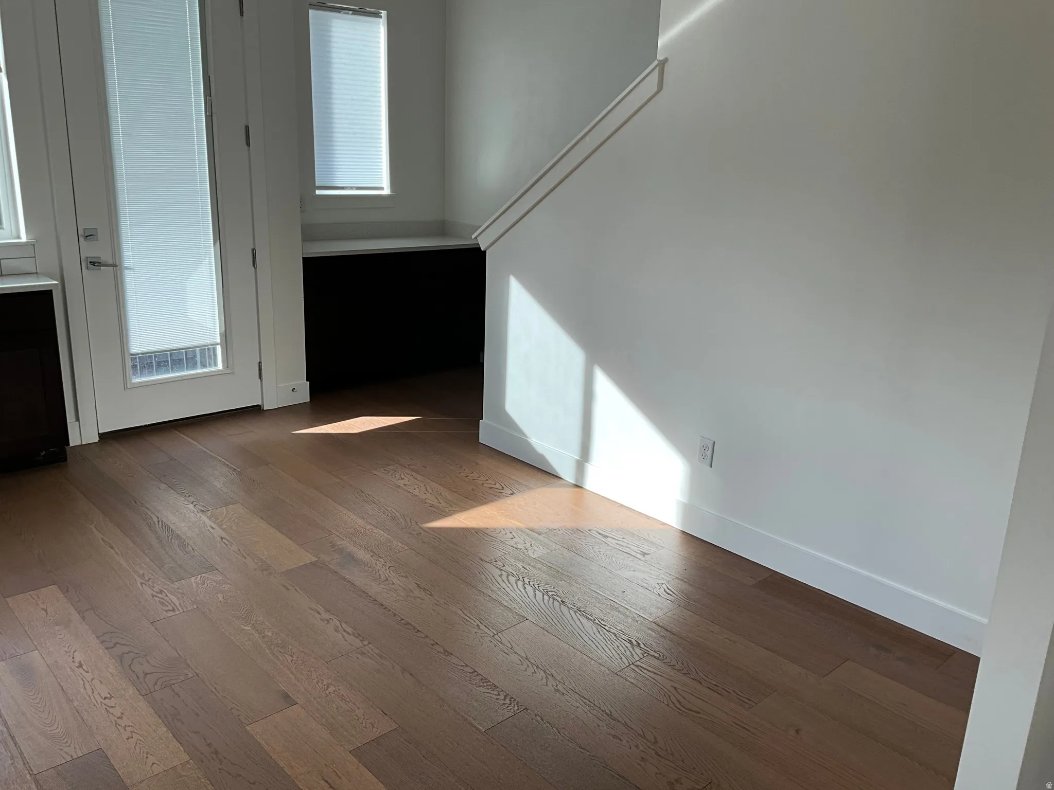 Empty room with wood-type flooring and baseboards