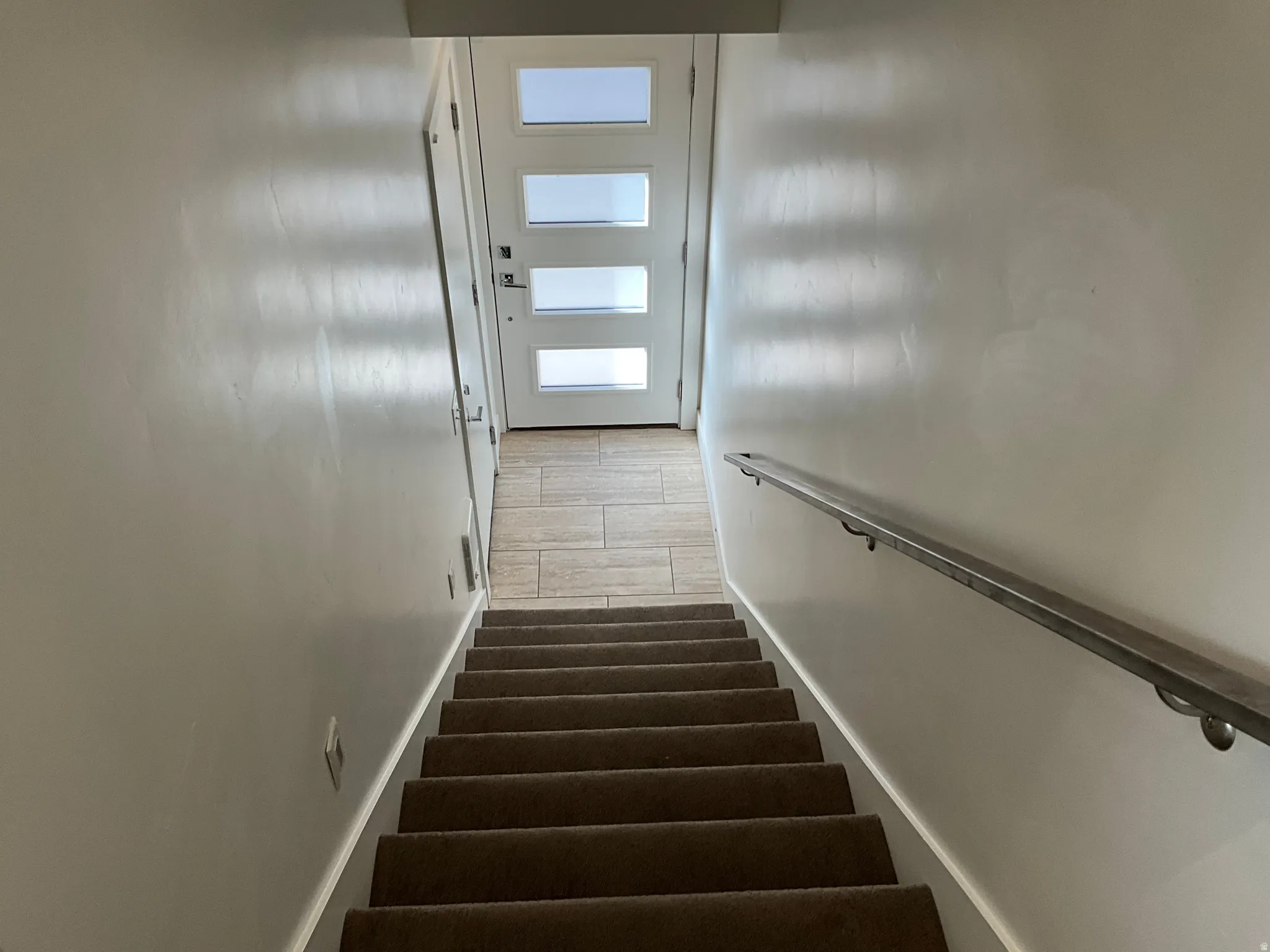 Staircase featuring wood tiled floors and baseboards