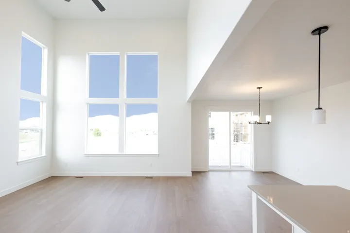 Two-story living area featuring high ceilings, wood-finish flooring, and expansive windows