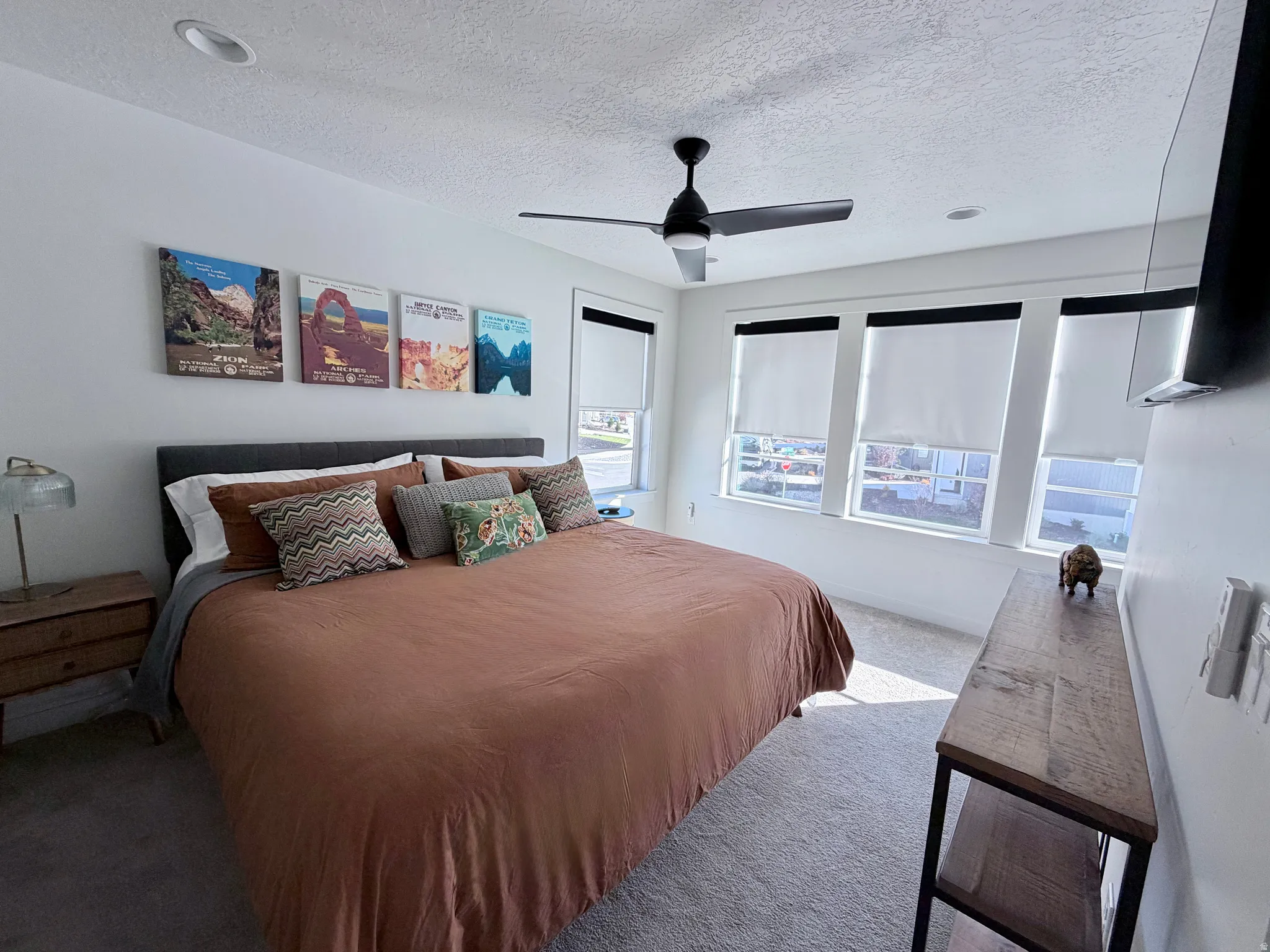 Carpeted bedroom with king bedroom furniture, bedding and decor