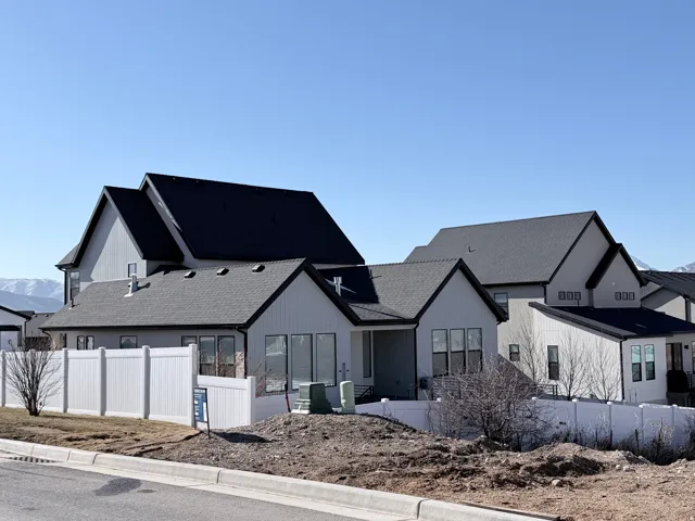 Rear view of house with a mountain view, a shingled roof, and a patio area