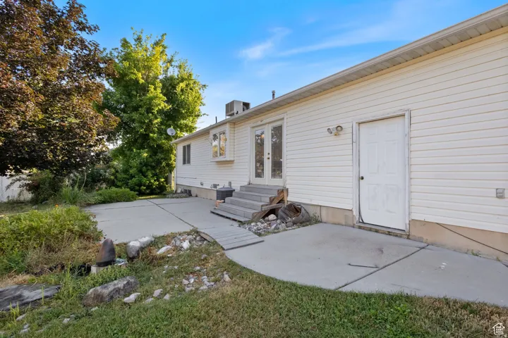 Rear view of house featuring a patio area, entry steps, and french doors