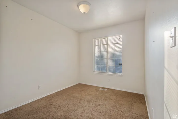 Carpeted empty room with baseboards
