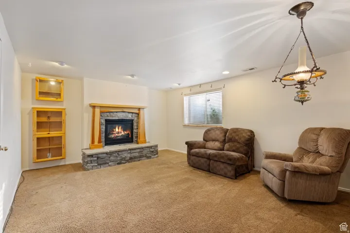 Living area featuring carpet floors, a fireplace, and recessed lighting