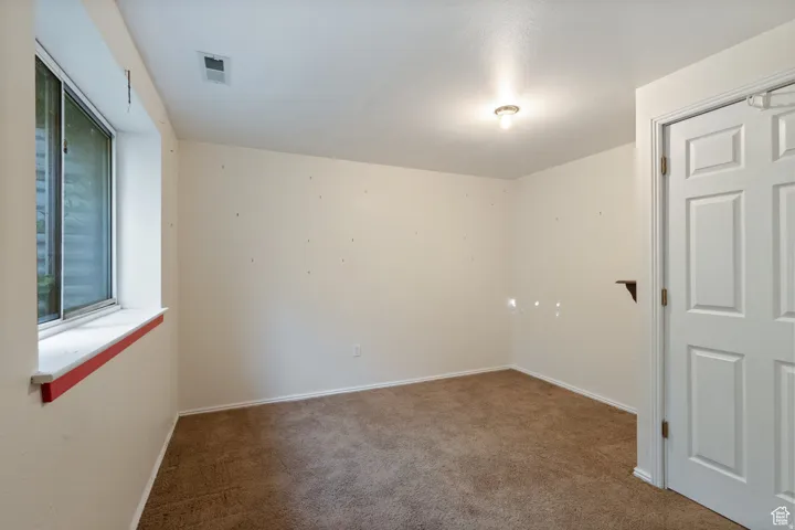Carpeted empty room with baseboards