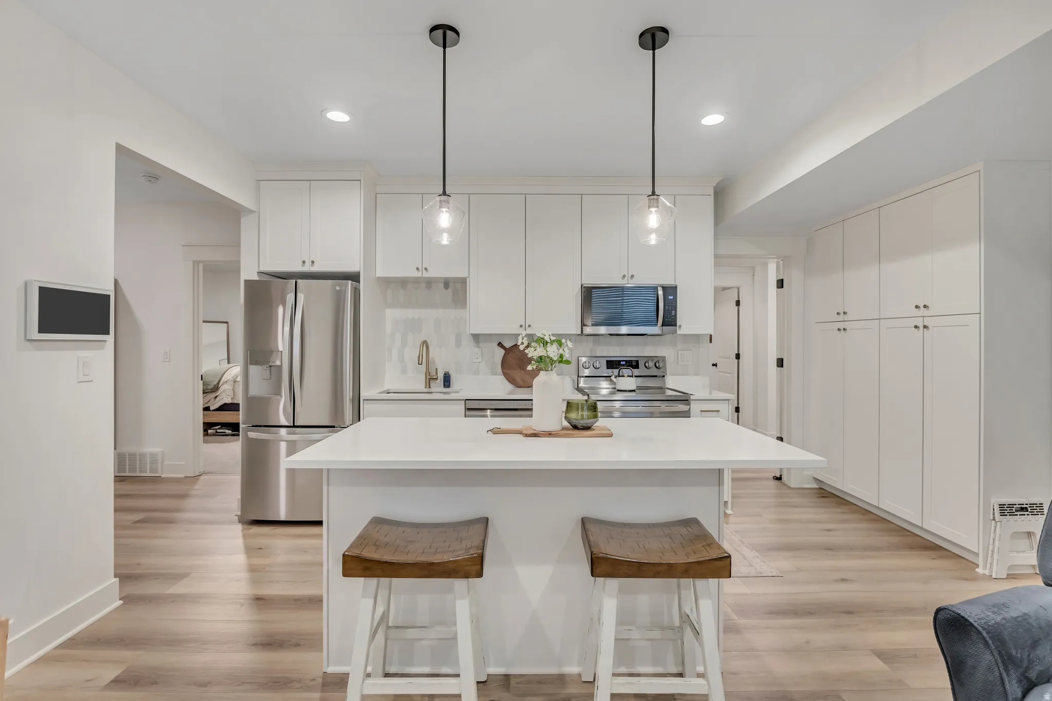 Mother in law kitchen, with island bar, quartz counter tops, stainless steel appliances.