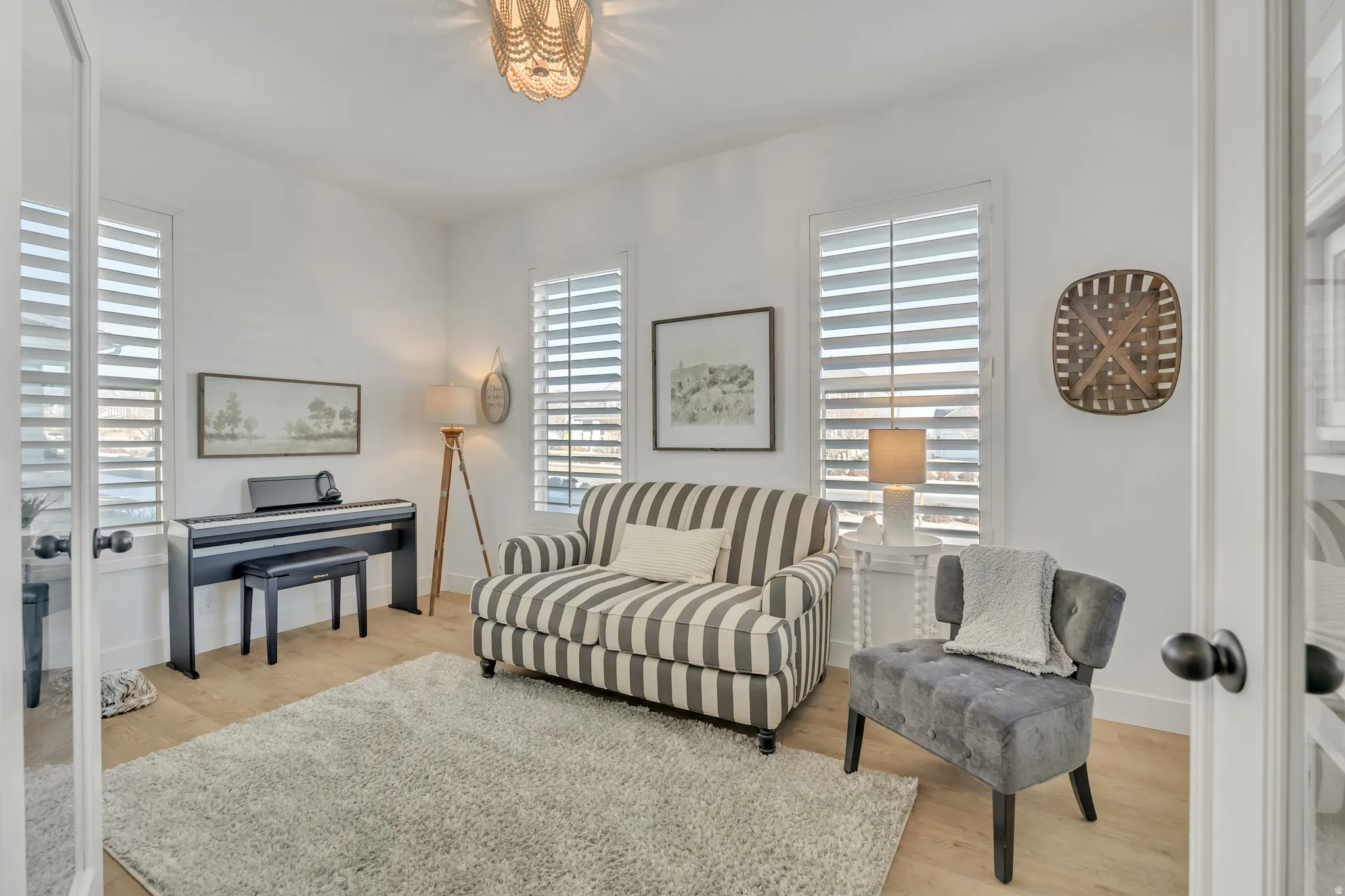 Office area with plantation shutters LVP flooring and french doors and closet.