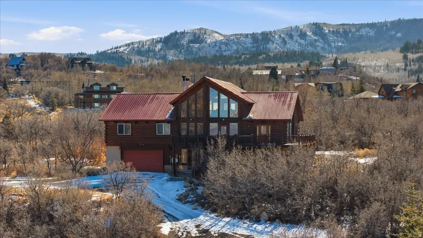 View of front of home with a garage, a mountain view, a chimney, and a metal roof