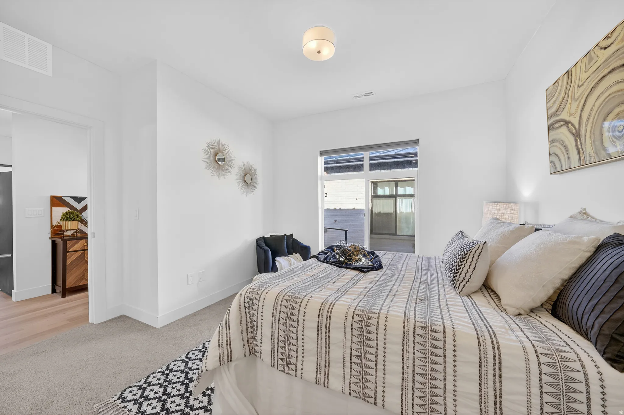 Bedroom with light colored carpet and high quality fridge