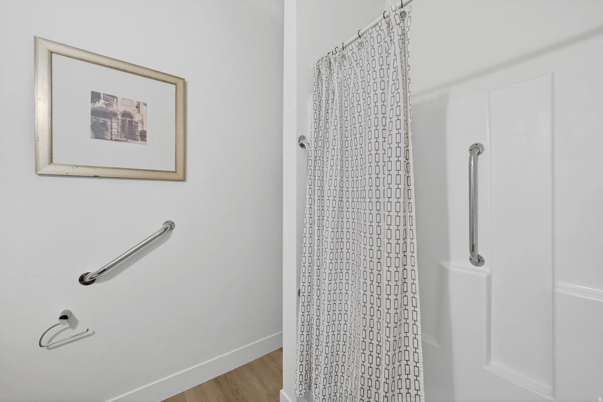 Full bath featuring curtained shower and wood finished floors