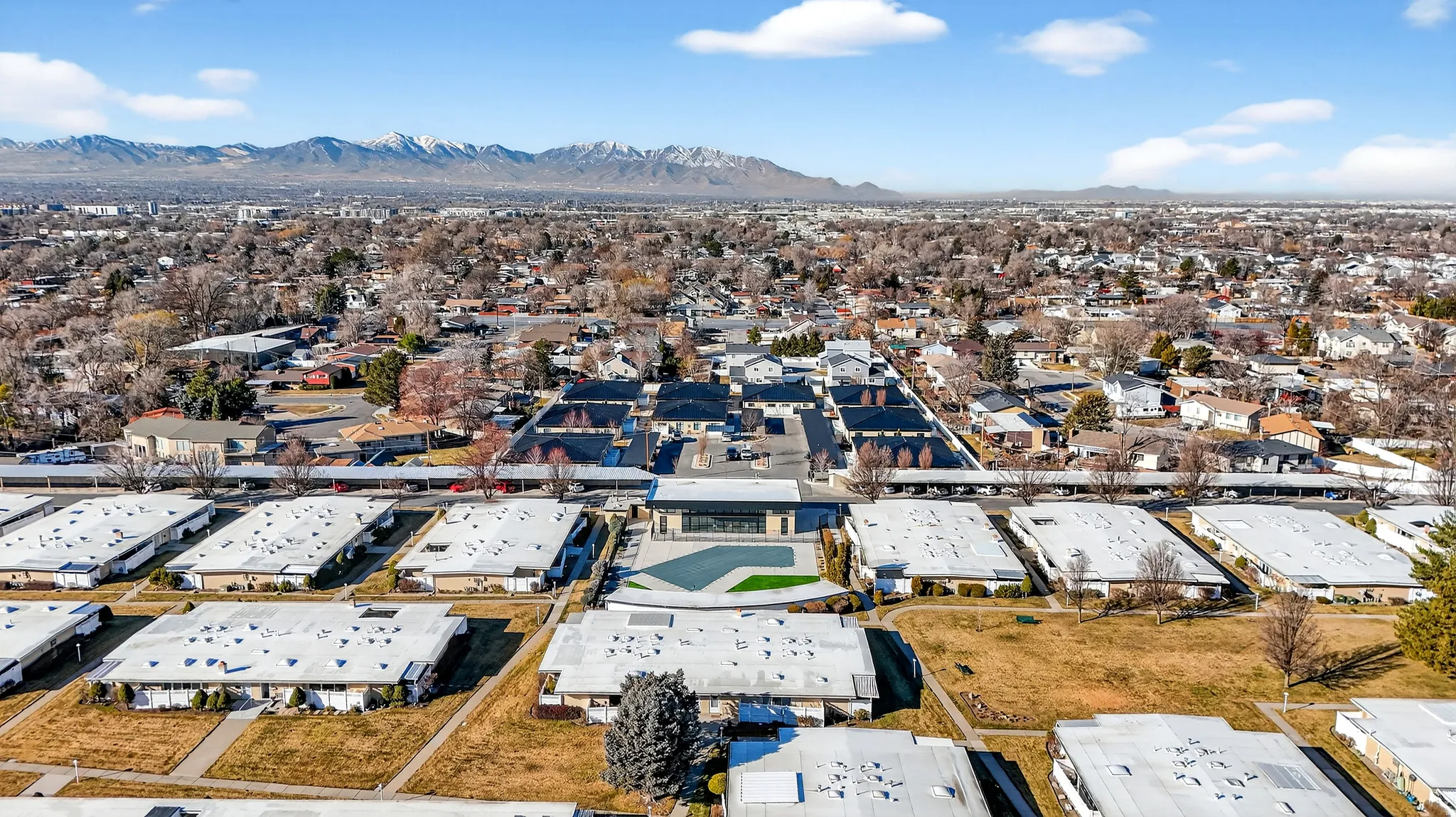 Aerial view of property and surrounding area with mountains and nearby suburban area