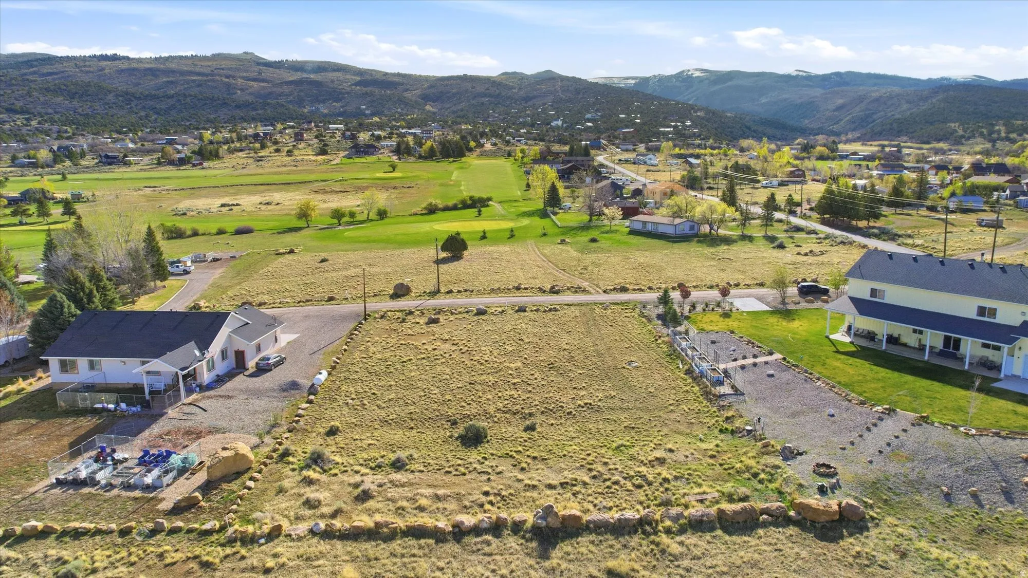 Expansive lot featuring a level, open terrain, mature perimeter trees, and mountain scenery