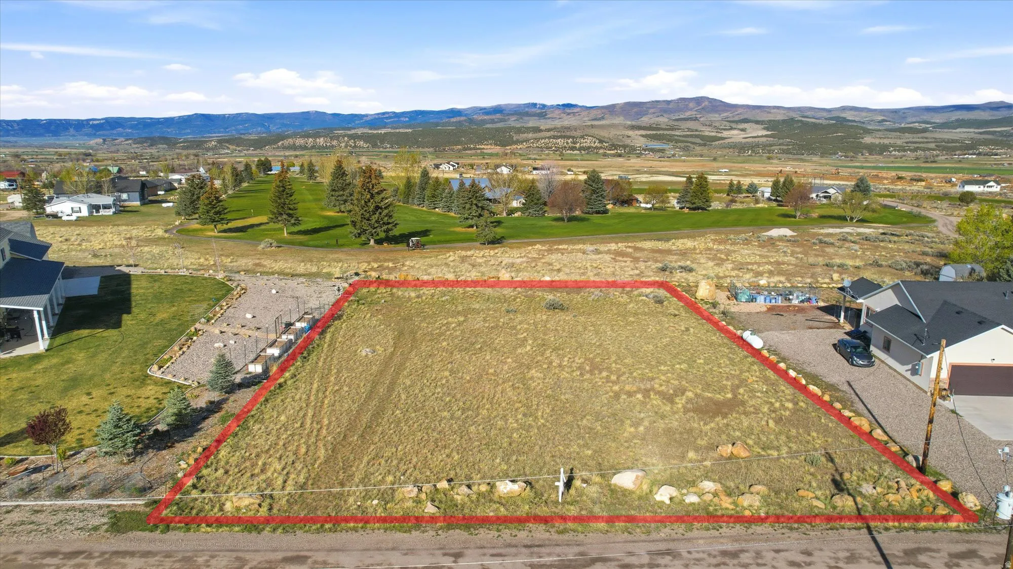 Unimproved parcel featuring a relatively level grade and natural vegetation, bordered by existing homes and open green spaces