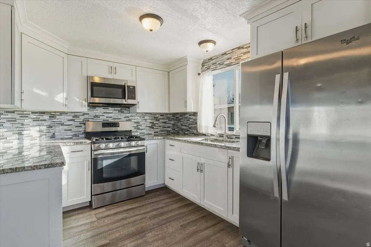 The updated kitchen features granite countertops, gas range, and stainless steel appliances, all included.