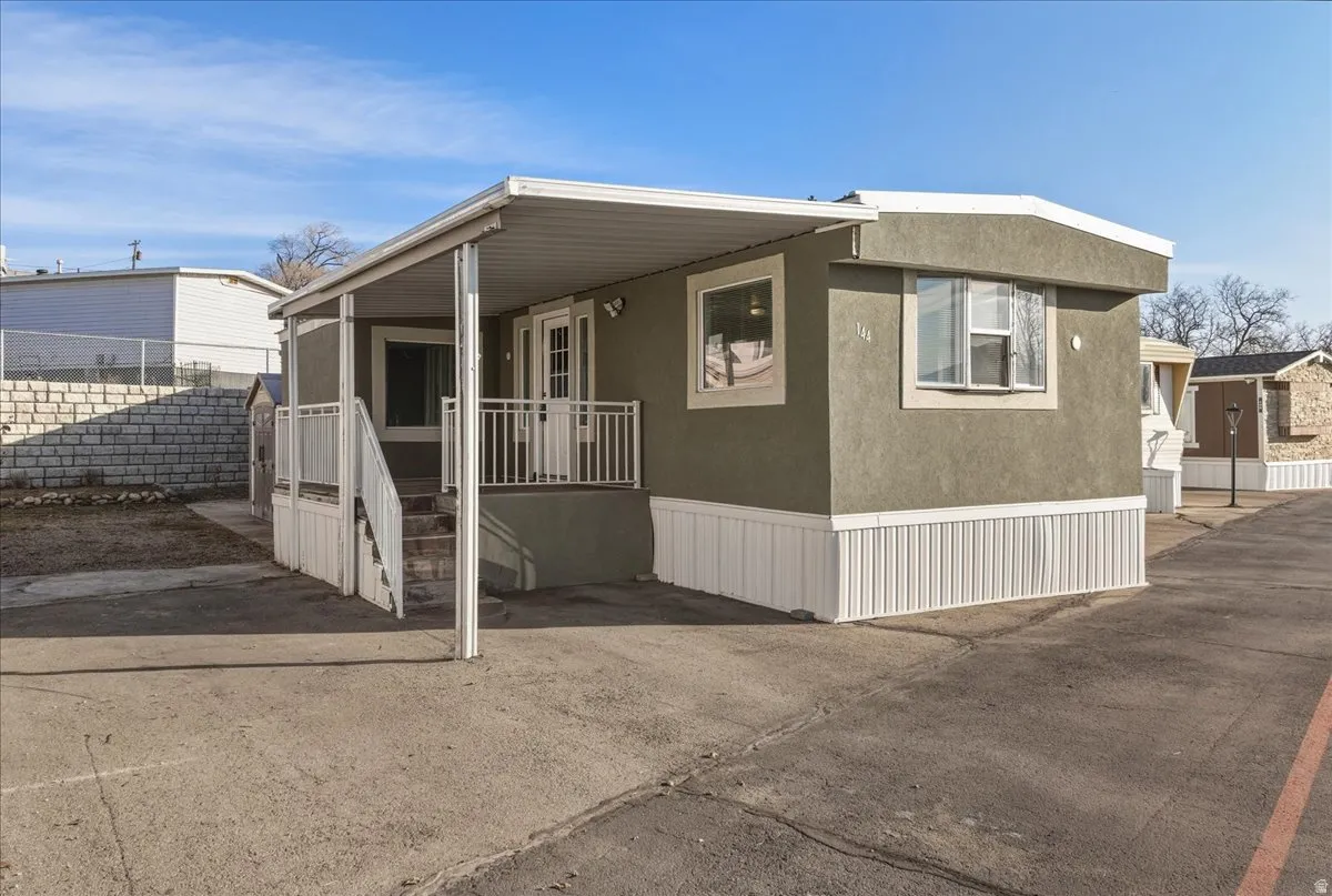 Updated 2-bedroom mobile home with a covered tiled front porch, newer roof, and attractive exterior, ideally located near UVU in Village Green Mobile Home Park.