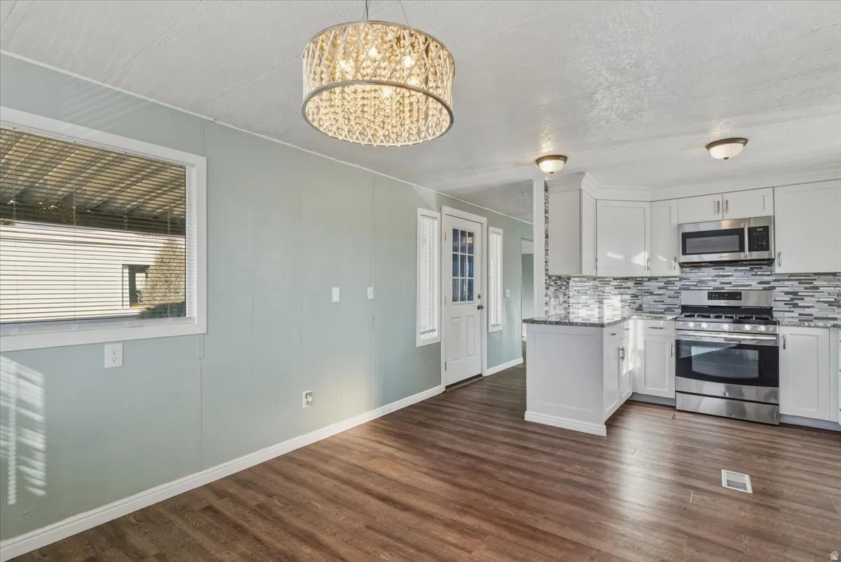 Durable LVP flooring flows throughout the space, creating a cohesive and modern feel. The adjacent dining area offers a comfortable spot for everyday meals or entertaining, with an open layout that makes the space feel bright and functional.