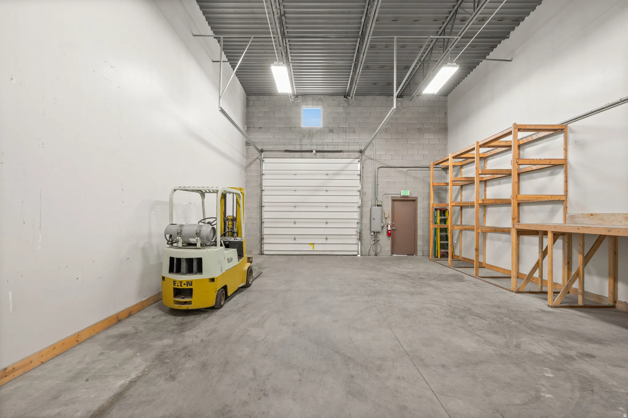 Garage featuring baseboards and electric panel