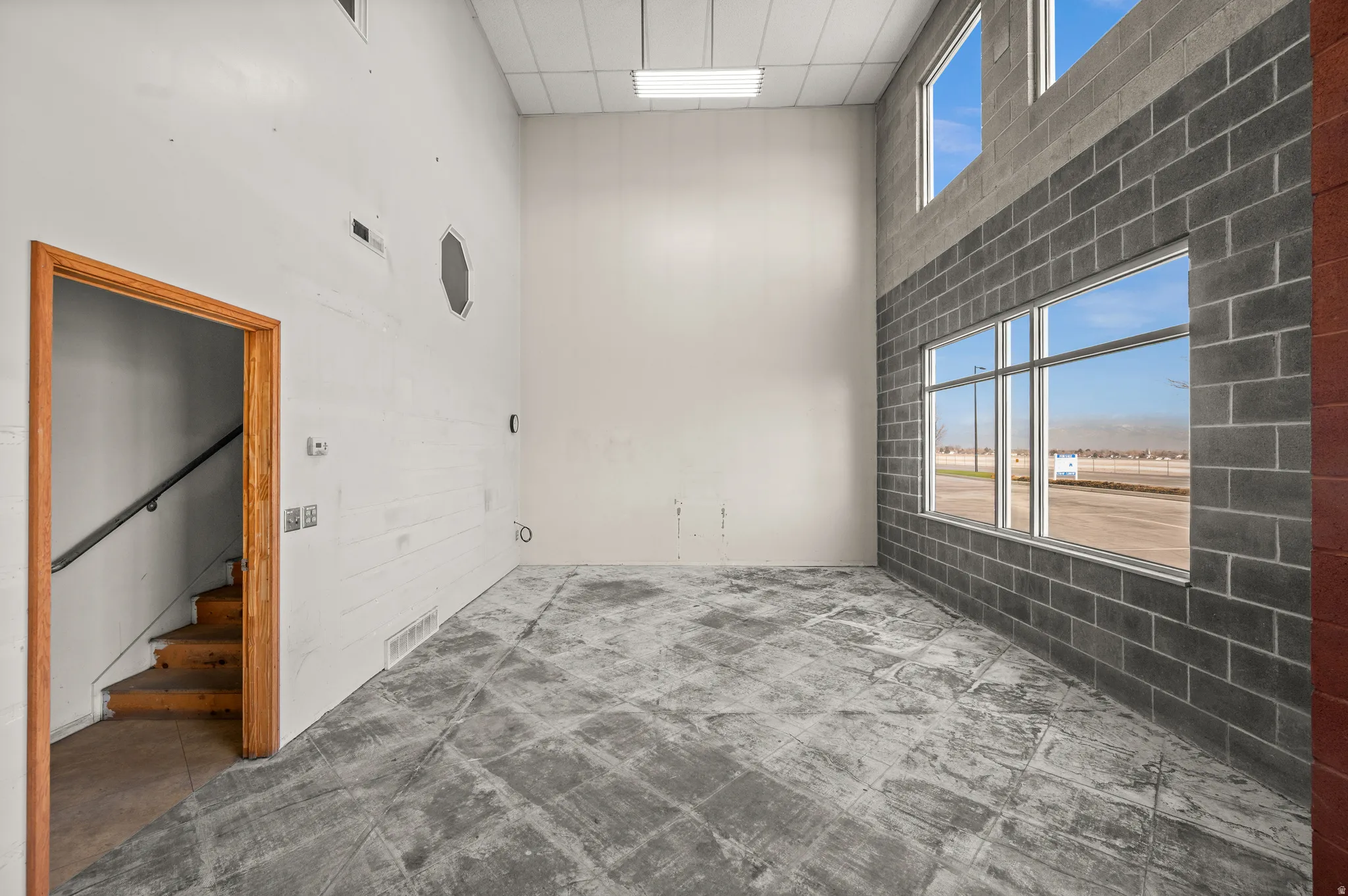 Unfurnished room with a high ceiling and stairway