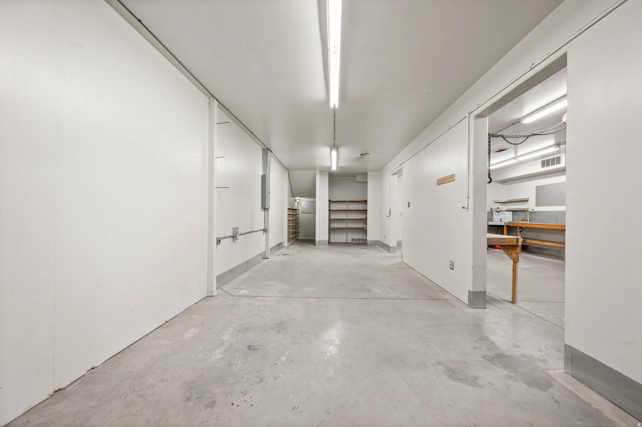 Corridor featuring unfinished concrete flooring