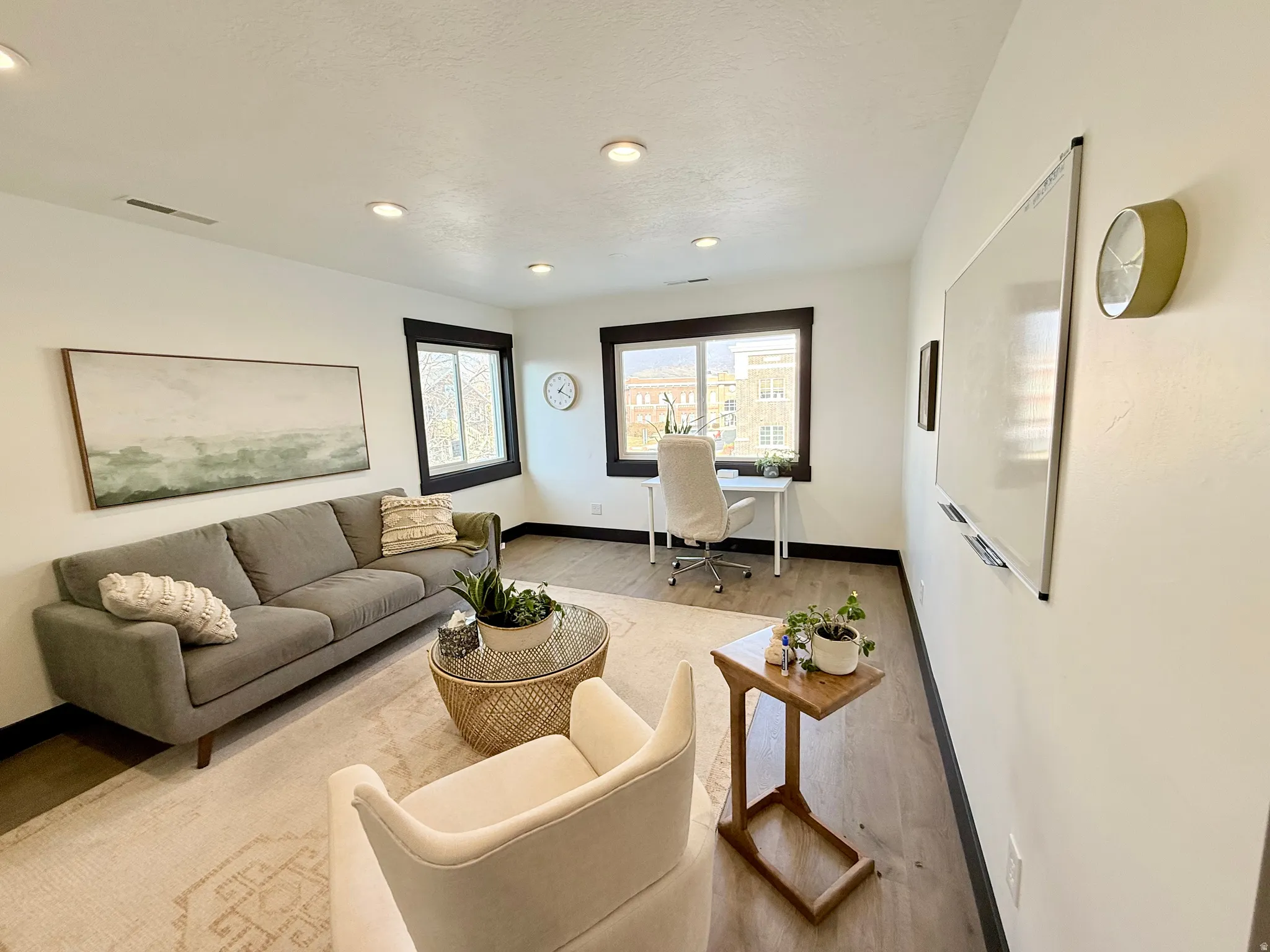 Living area featuring wood finished floors, a desk, and recessed lighting