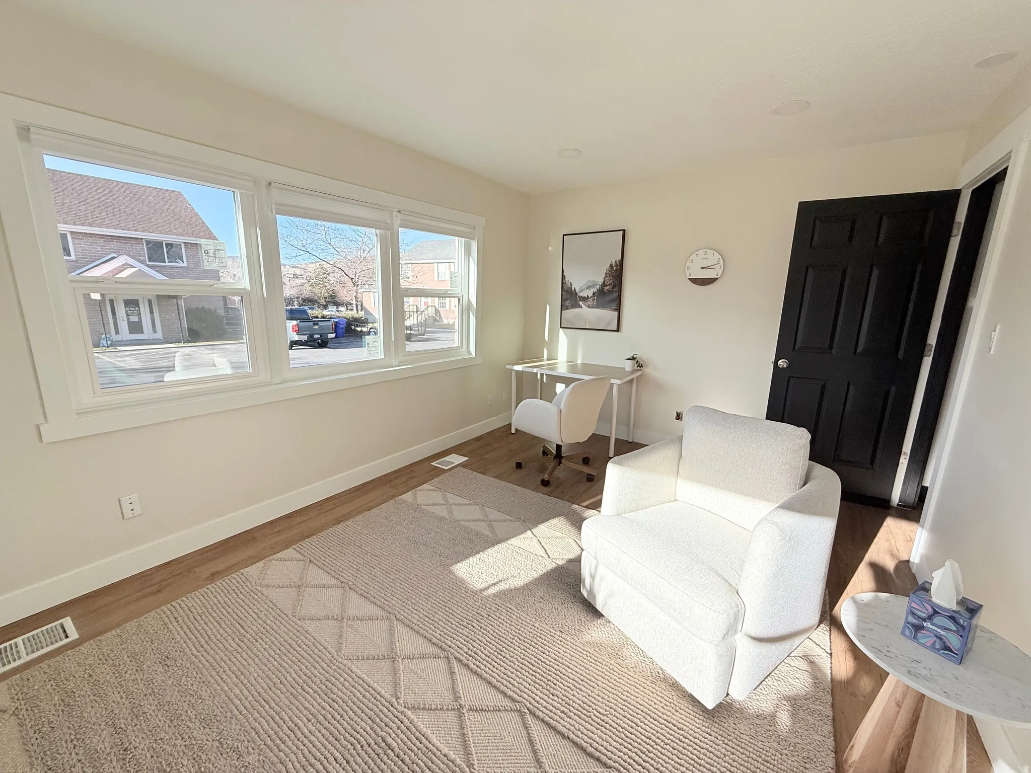 Living area with wood finished floors and a desk
