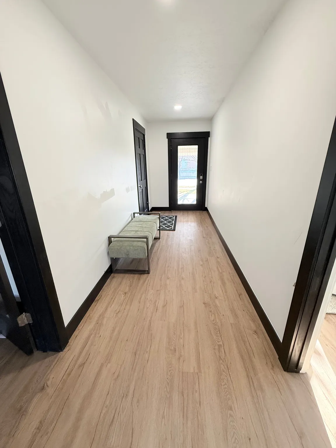 Hall with light wood-style floors and baseboards