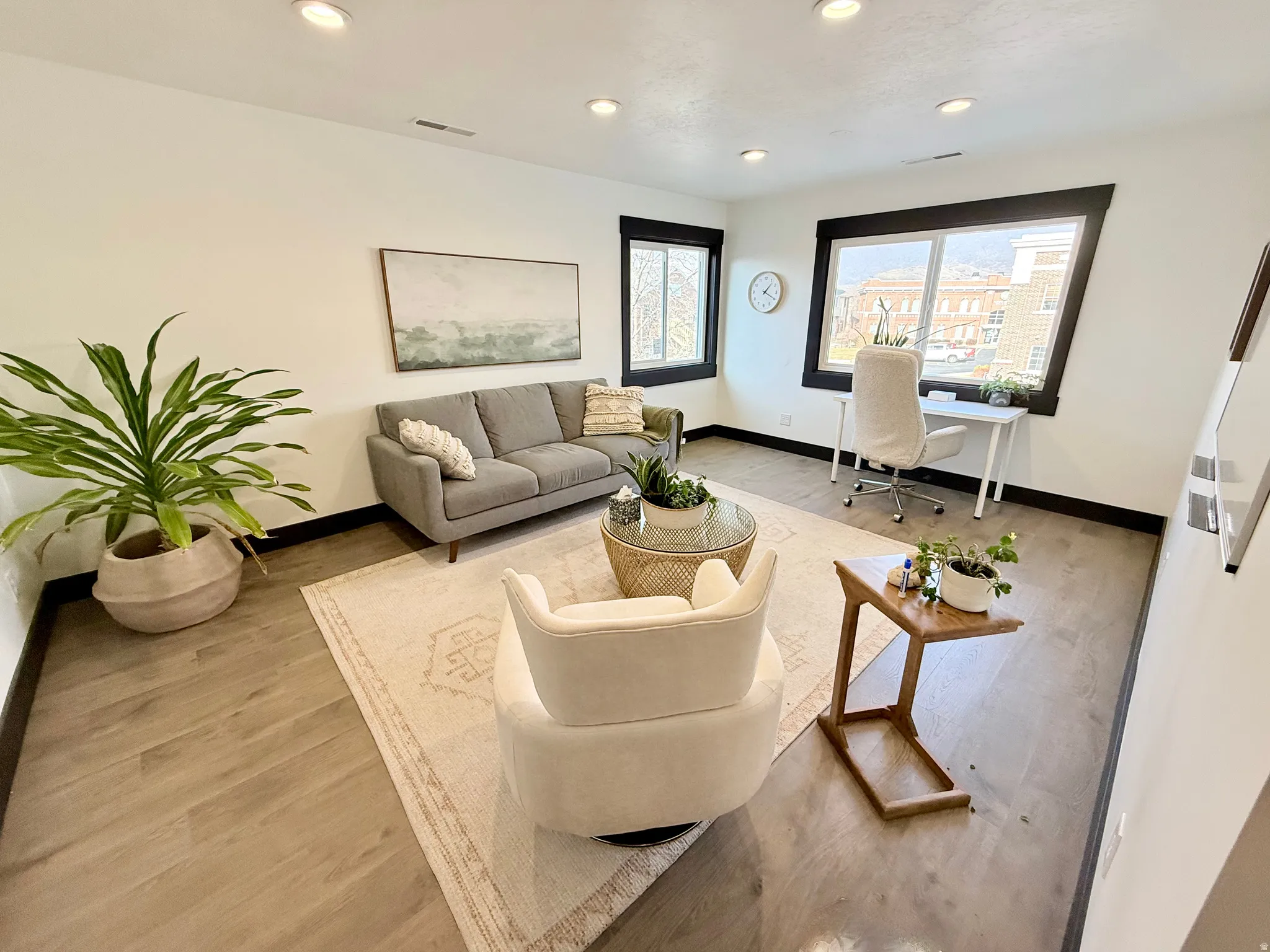 Living room with light wood finished floors, recessed lighting, and an office area