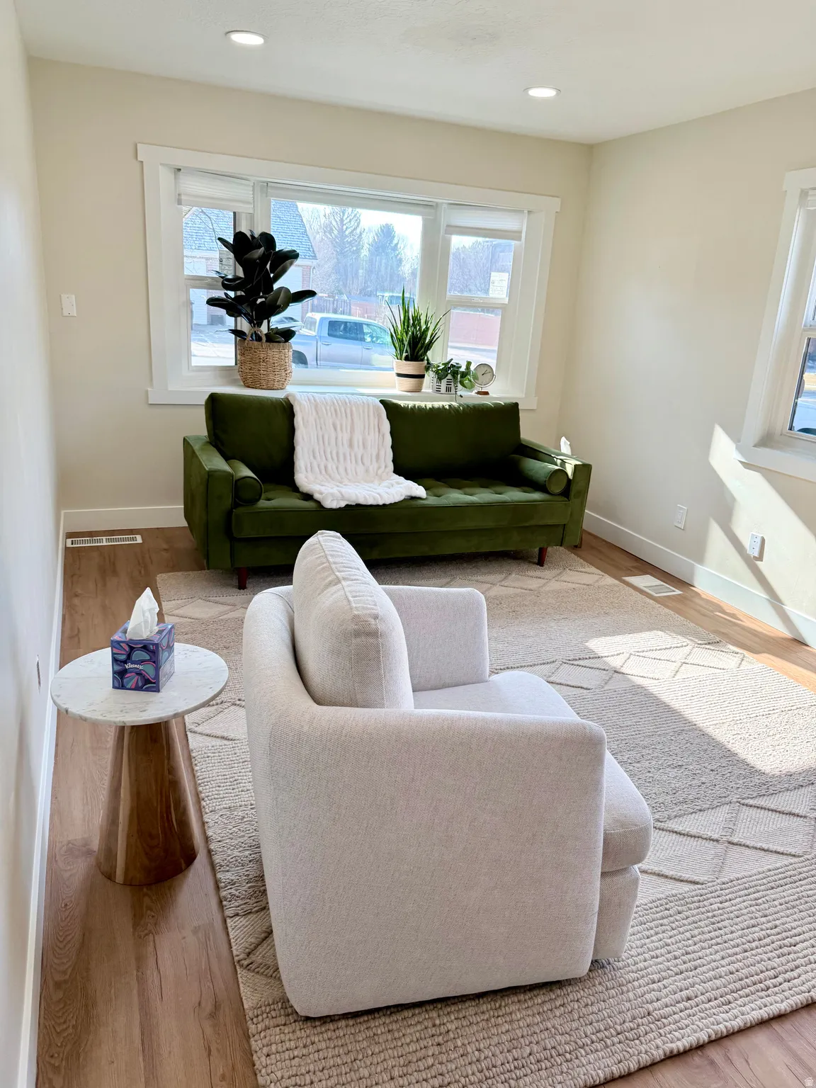 Living room with light wood-style floors, plenty of natural light, and recessed lighting