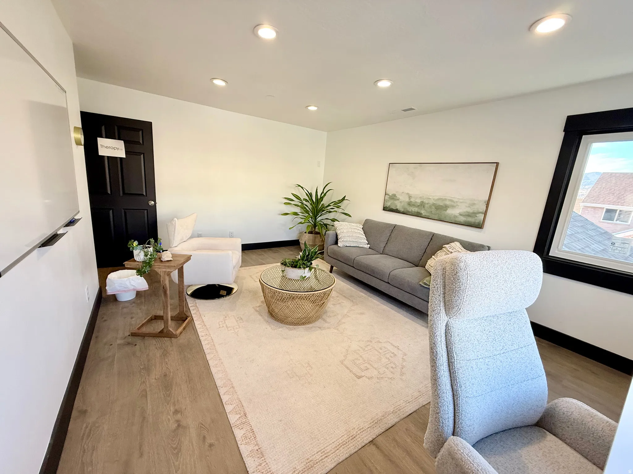 Living room with light wood-style flooring and recessed lighting