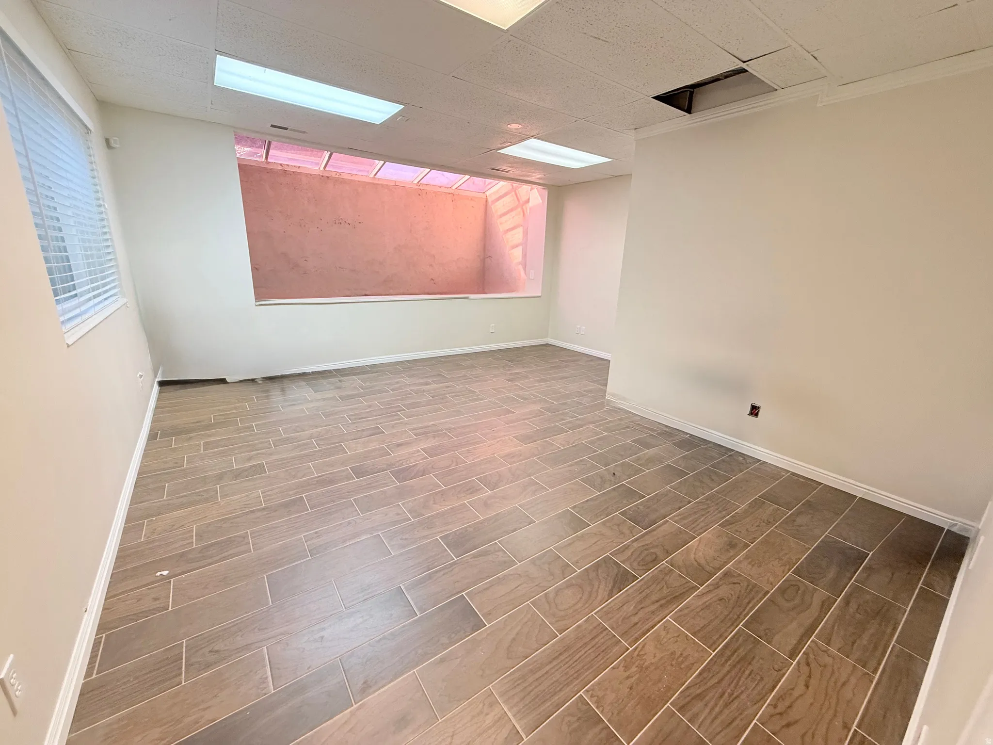 Spare room featuring a drop ceiling and wood finish floors