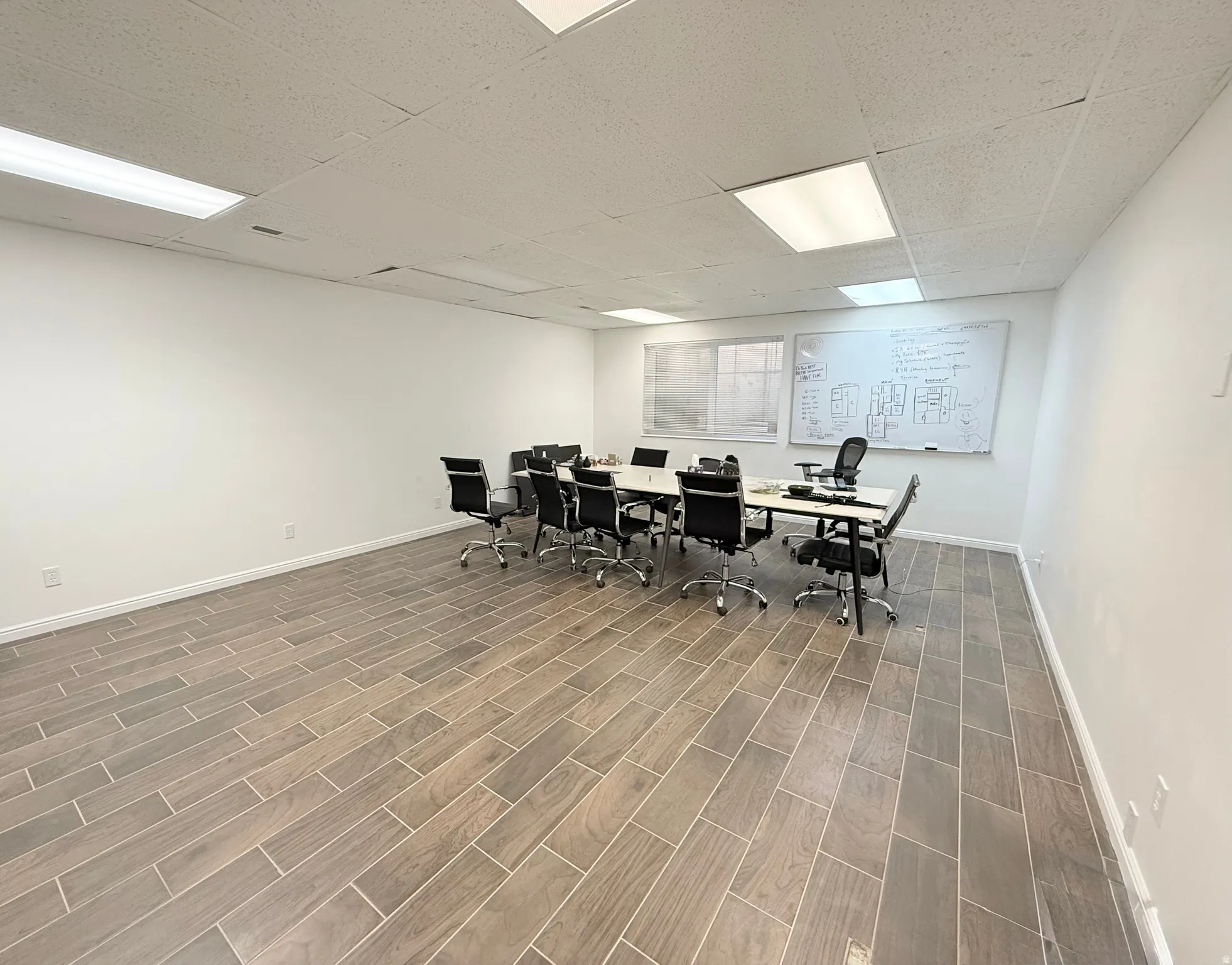Dining space featuring wood tiled floors and a drop ceiling