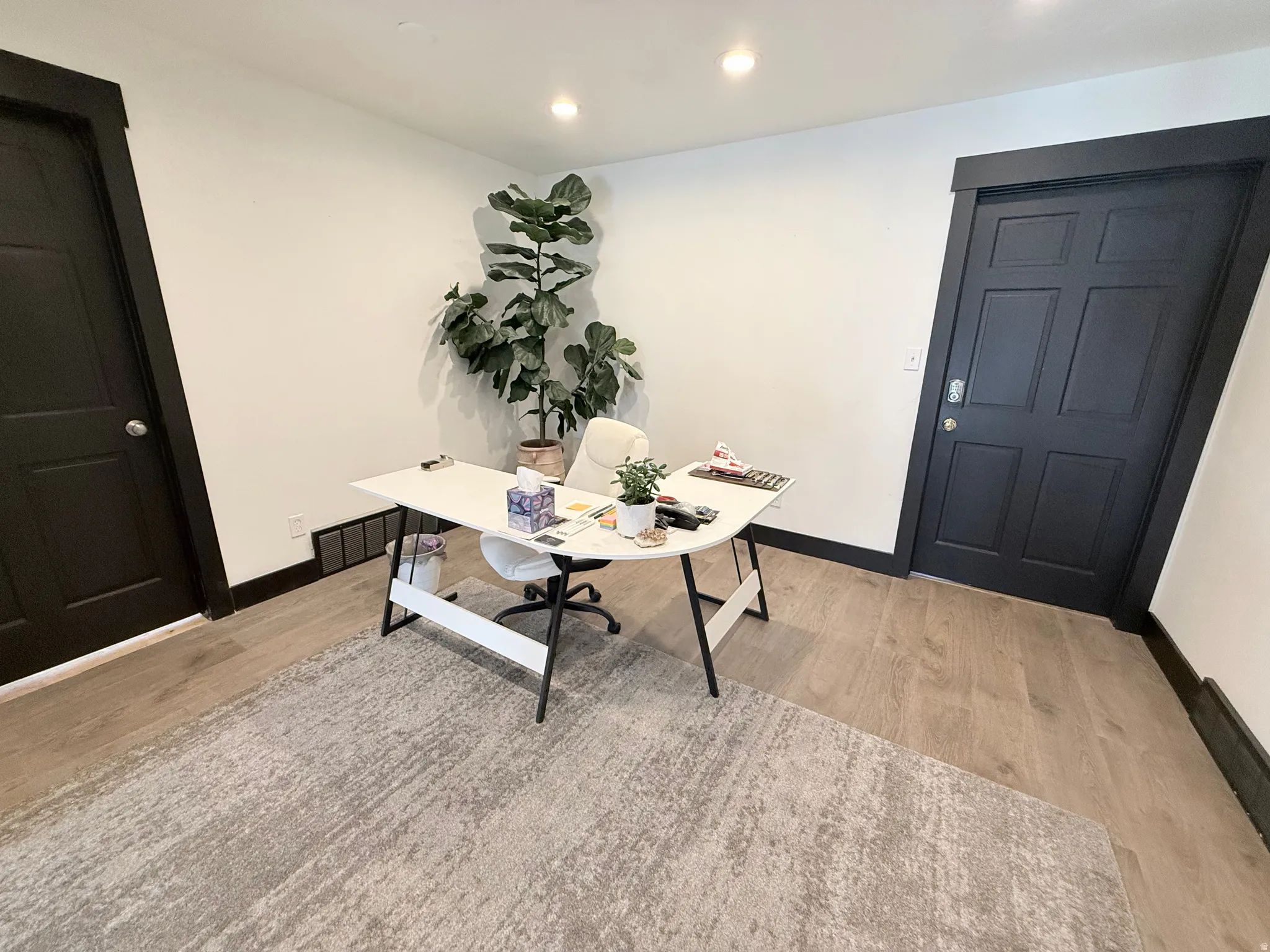 Home office with light wood-type flooring and recessed lighting