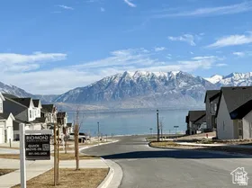 View of asphalt street with a mountain view, curbs, sidewalks, and a residential view