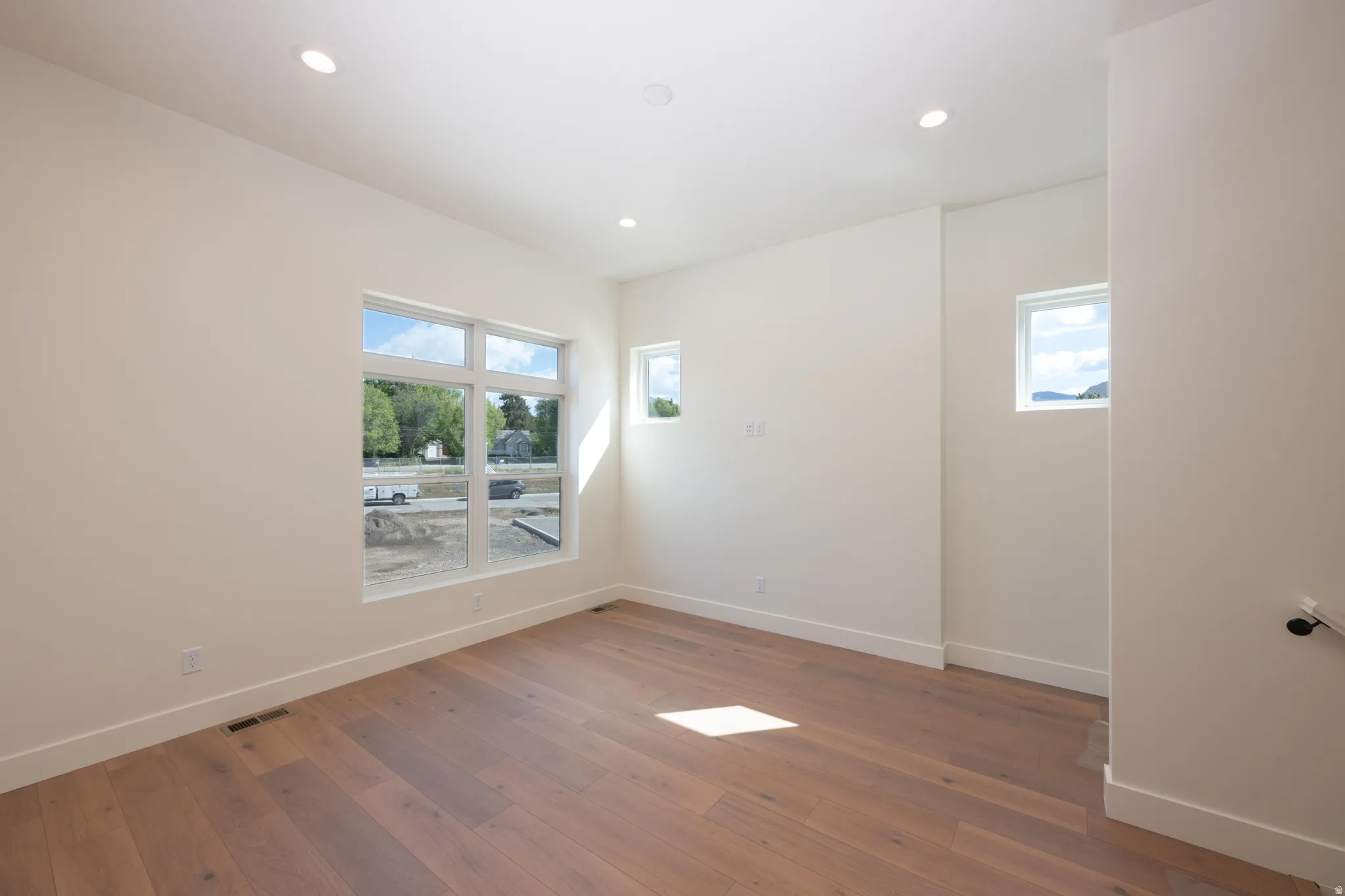 Empty room featuring dark wood-style flooring and recessed lighting