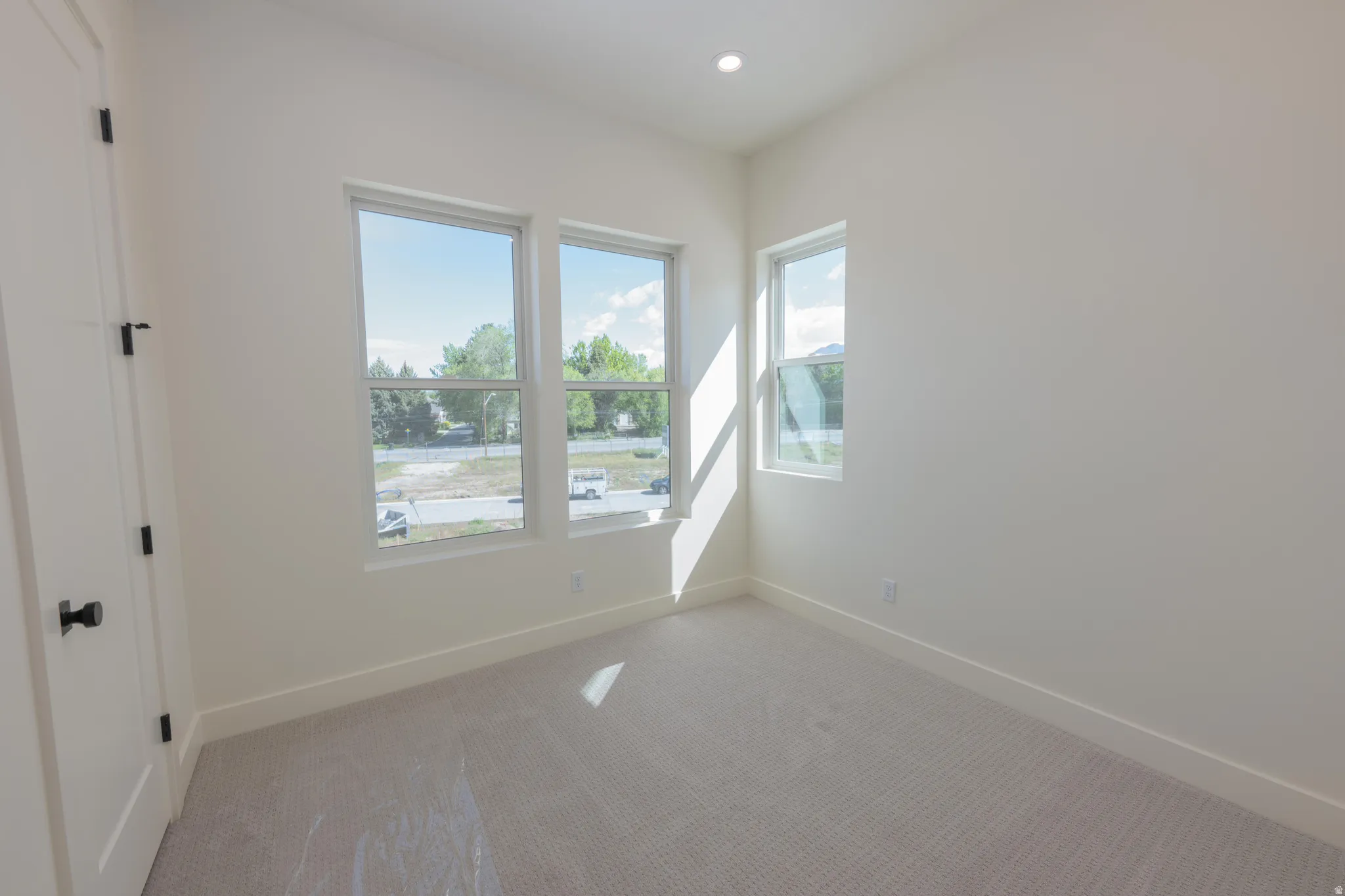 Carpeted empty room featuring baseboards and recessed lighting