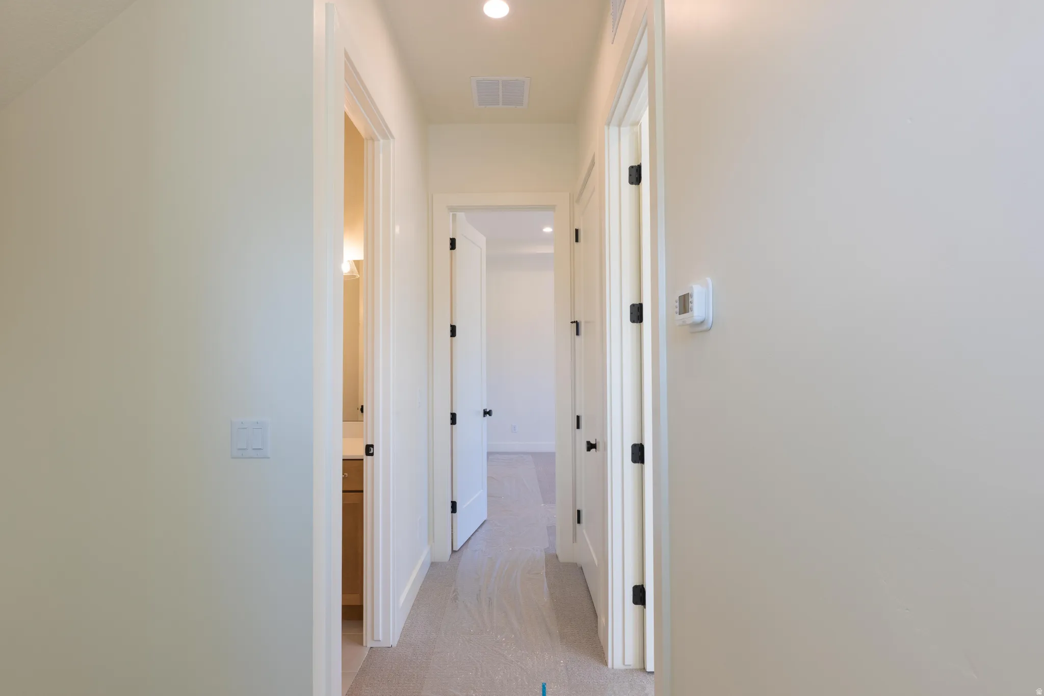Hallway featuring recessed lighting and baseboards