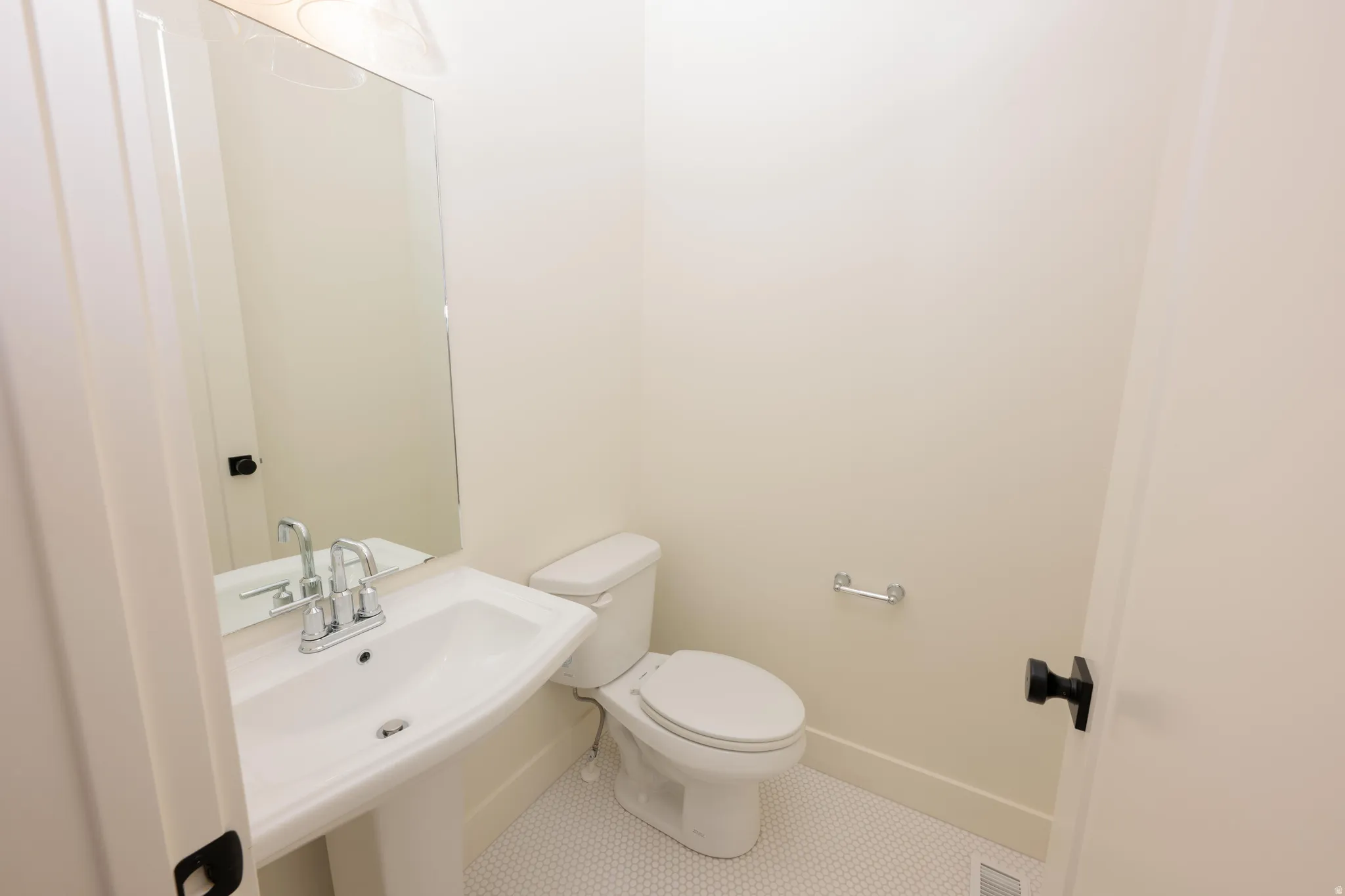 Half bath with tile patterned flooring and toilet