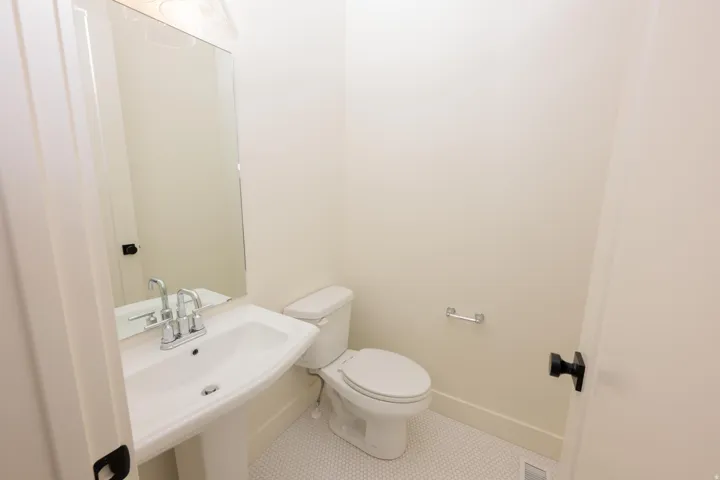 Half bath with tile patterned flooring and toilet