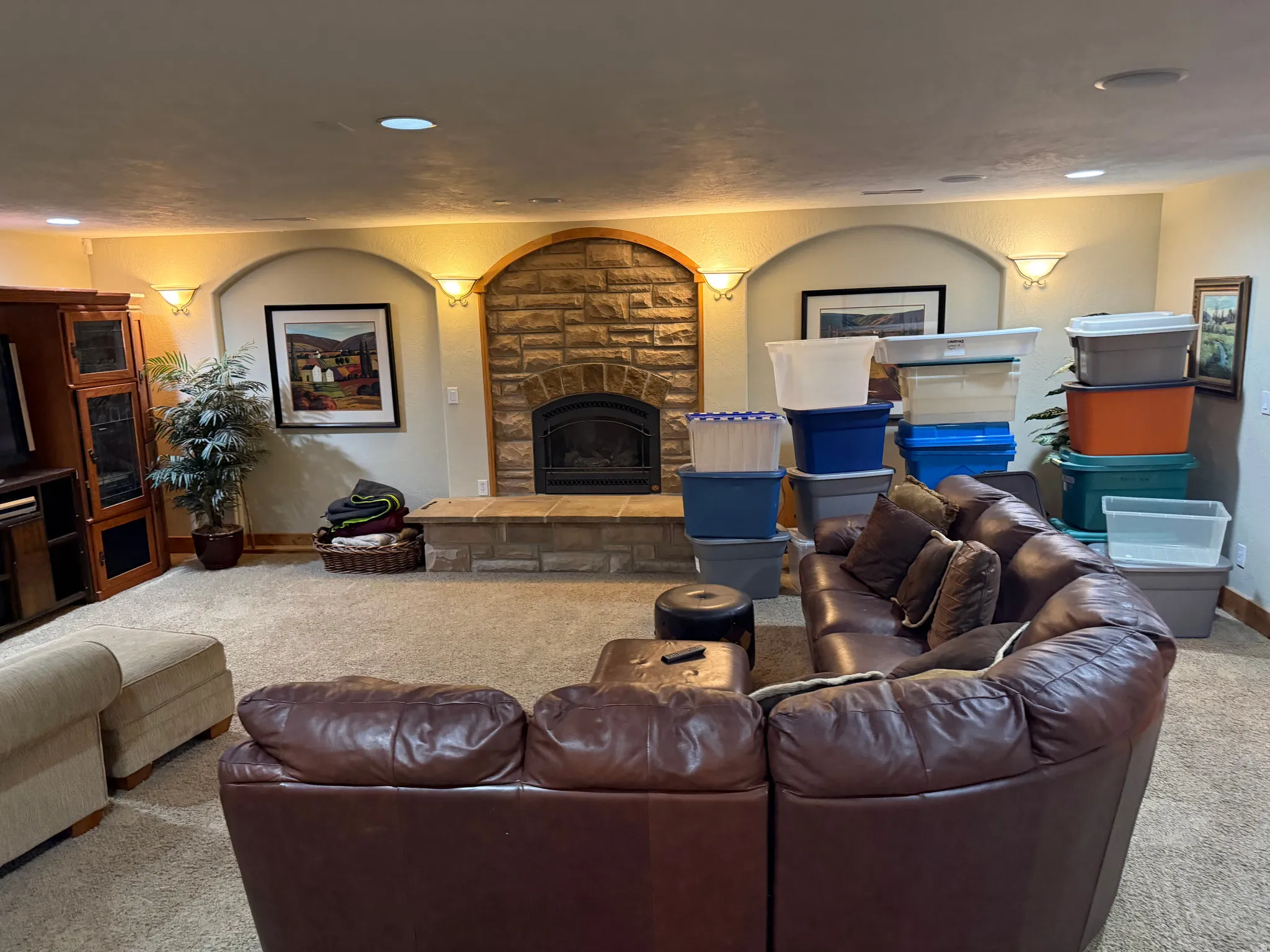 Carpeted living area featuring a fireplace, a textured wall, and recessed lighting