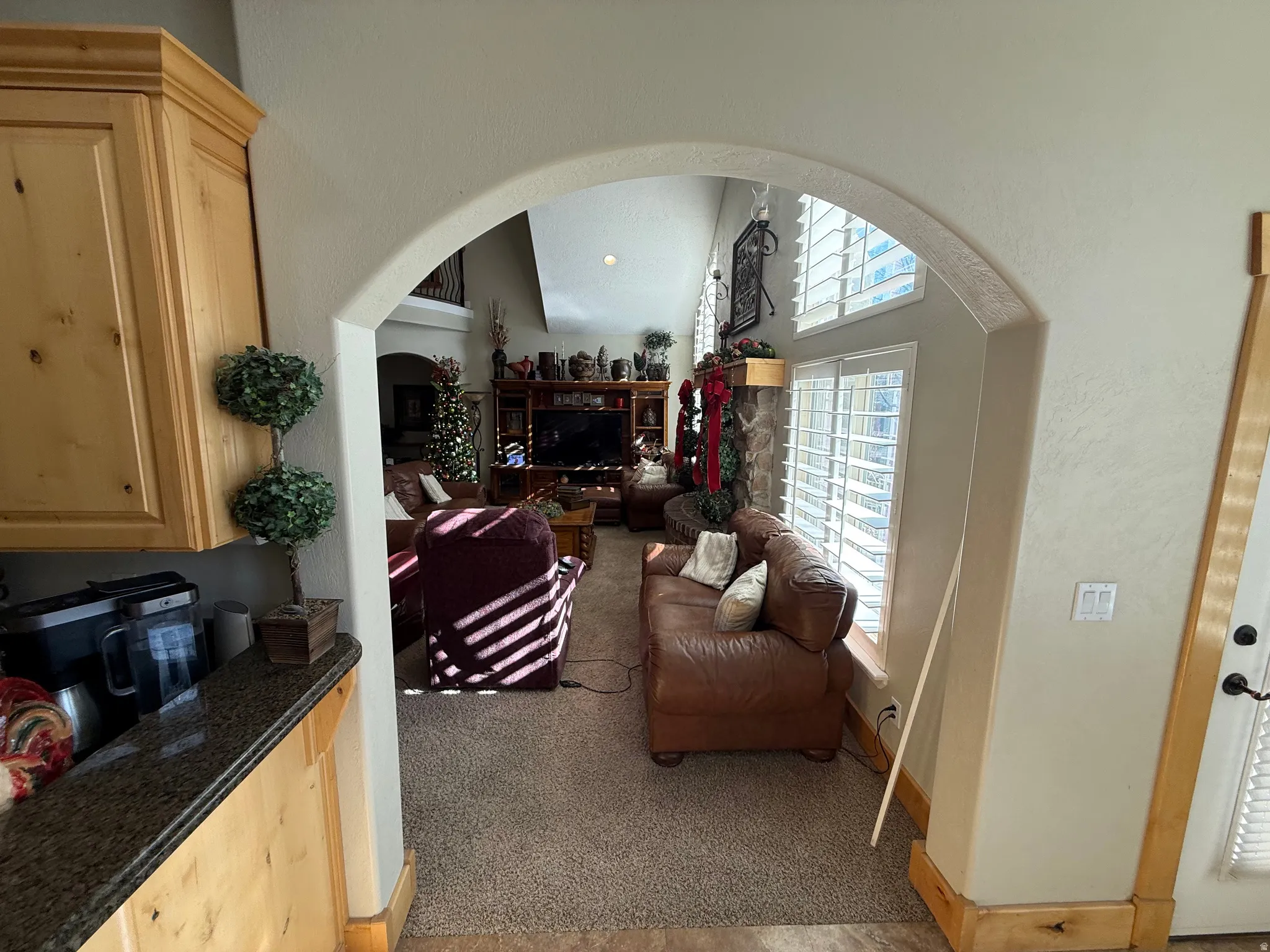 Living room with arched walkways and light carpet