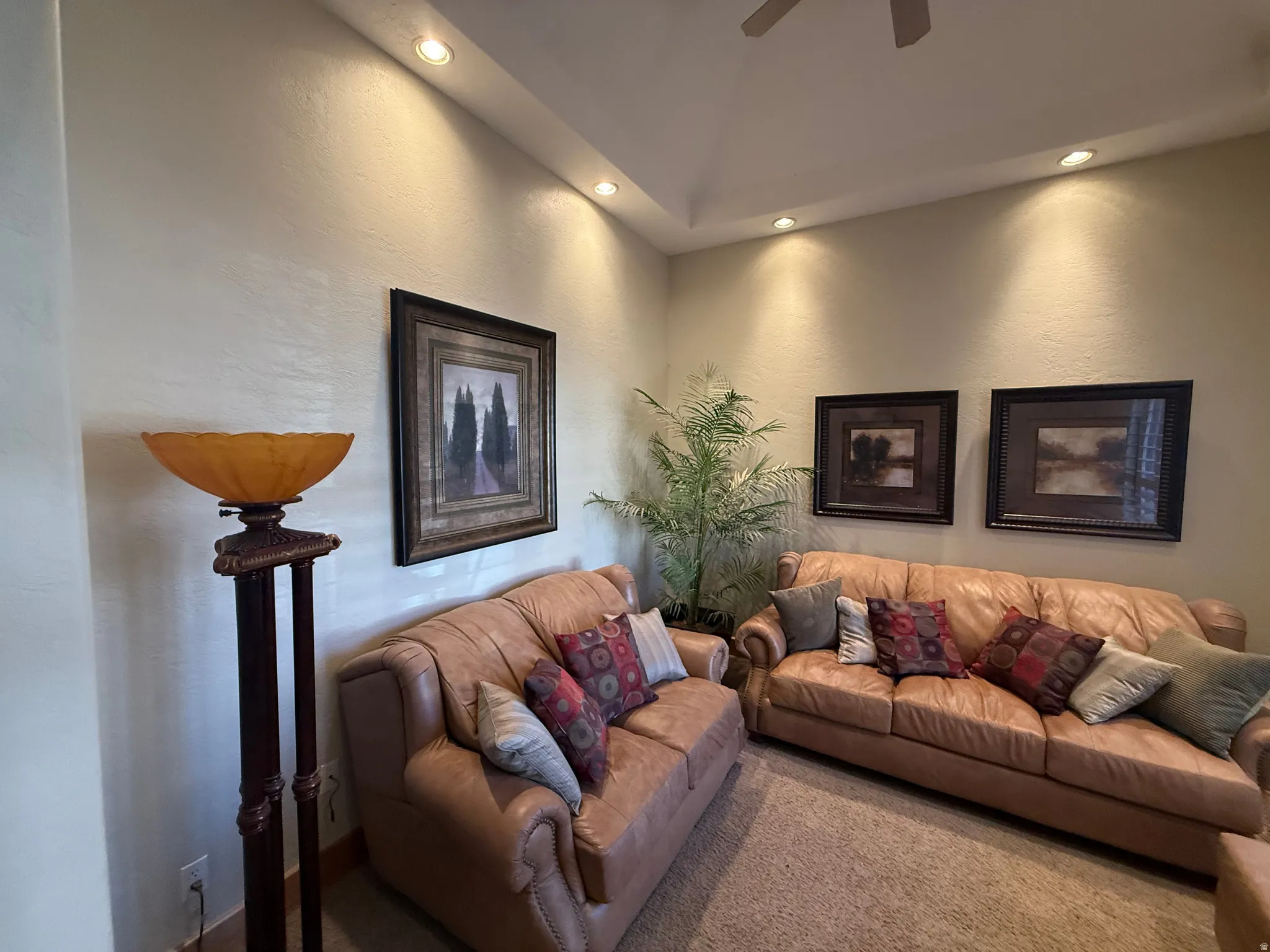 Living room featuring ceiling fan, a textured wall, carpet, and recessed lighting