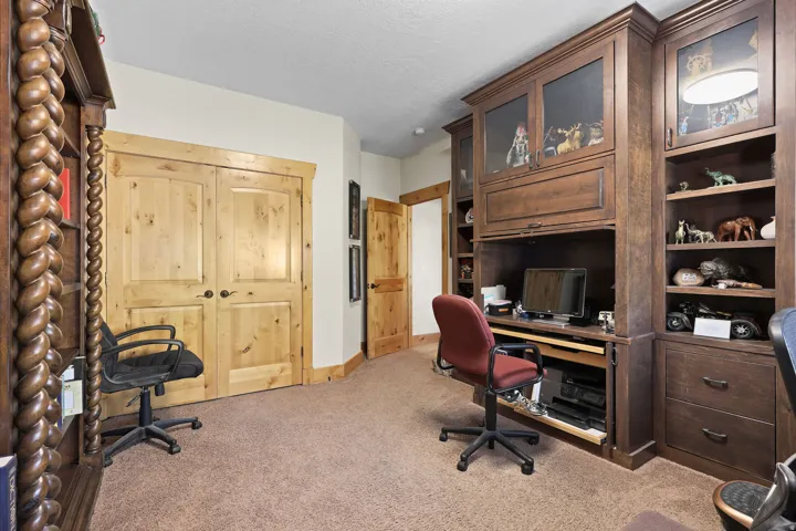 Custom built-in wood cabinetry with glass-front uppers and a dedicated desk area