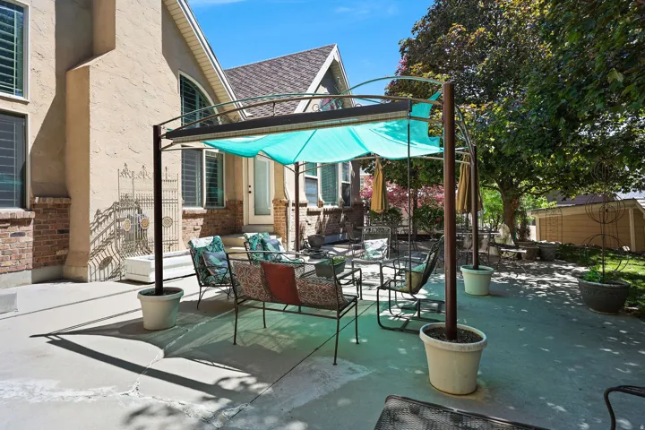 Expansive concrete patio featuring a metal pergola with a retractable shade
